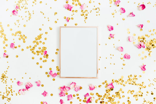 Photo frame mock up with space for text, pink rose petals and golden confetti on white background. Flat lay, top view. Valentine's minimal background.