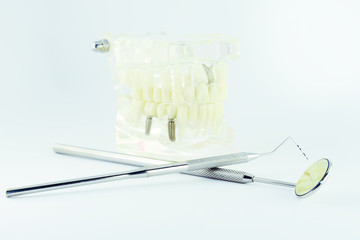 Photo, dental instruments, mirror with a handle, tooth model, probe, tweezers, drawing a tooth on a light background with a place under the text