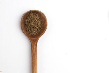 CARAWAY. ISOLATED SPICE ON WOODEN SPOON ON WHITE BACKGROUND