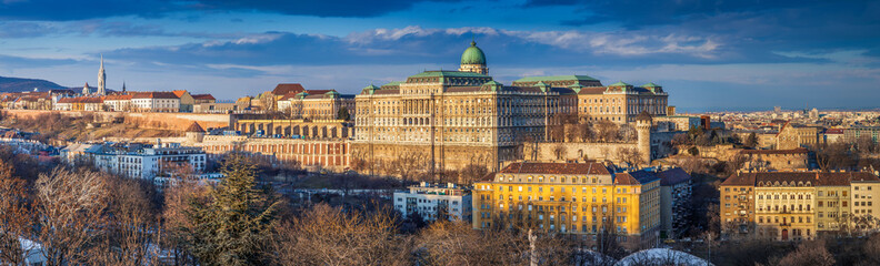 Budapest, Hungary - Ultra wide panoramic skyline view of the beautiful Buda Castle Royal Palace with parliament of Hungary at sunset with blue sky and clouds