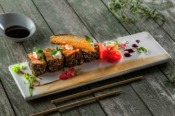 Delicious Japanese food sashimi. Salmon rolls on a square plate. Fresh healthy Asian seafood meal on a wooden table.
