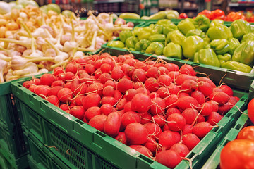 Red radish and another vegetables in grocery store, toned