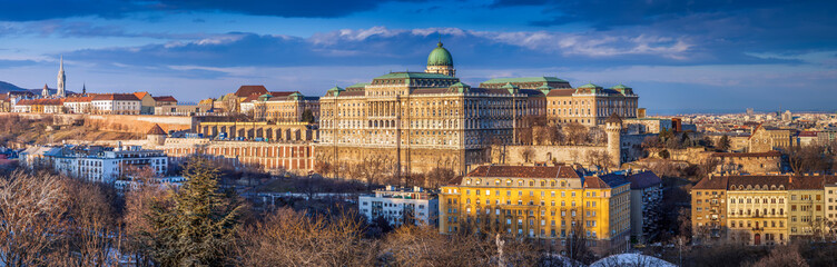 Budapest, Hungary - Ultra wide panoramic skyline view of the beautiful Buda Castle Royal Palace with parliament of Hungary at sunset with blue sky and clouds