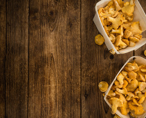 Portion of Chanterelles on wooden background, selective focus