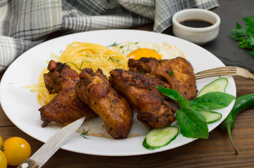 Fried chicken wings with spaghetti. Wooden background. Close-up. Top view