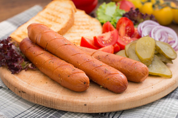 Food set for hot dog, sausage, canned cucumbers, lettuce leaves, tomatoes, onions, croutons on the wooden background. Close-up. Top view