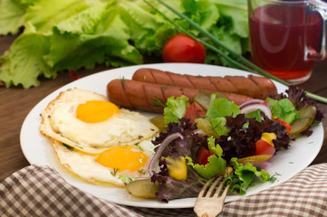 English breakfast - toast, egg, sausages and vegetables salad. Wooden rustic background. Close-up. Top view