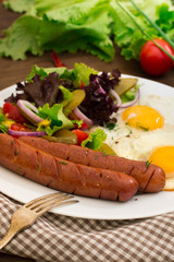 English breakfast - toast, egg, sausages and vegetables salad. Wooden rustic background. Close-up. Top view