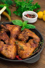 Baked chicken wings in baking pan. Selective focus. Wooden background. Close-up. Top view