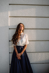 Portrait of beautiful young brunette woman in a long blue dress