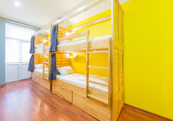 Hostel dormitory beds arranged in room - obrazy, fototapety, plakaty
