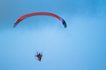 A man is flying on a paraglider in the sky