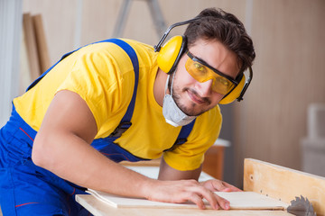 Young repairman carpenter working with a circular saw