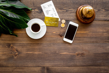 Ask for the bill at cafe. Service bell near coffee and bank card on wooden table top view copyspace
