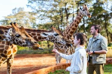 Family feeding giraffes in Africa