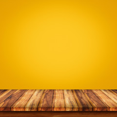 Empty top of wooden table on yellow gradient wall background.