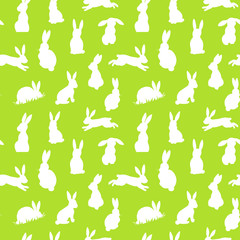 Seamless vector background with white easter rabbits silhouettes on a green background