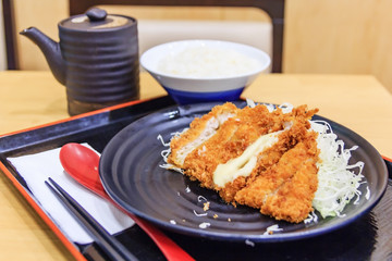 Tonkatsu is a Japanese dish which consists of a breaded, deep-fried pork cutlet./ Deep Fried Pork Loin Cutlet with Salad and Lemon, Japanese Food
