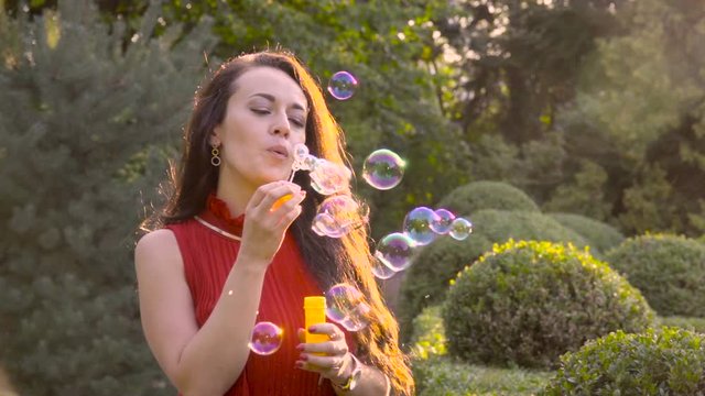 Girl blowing soap bubbles in slow motion