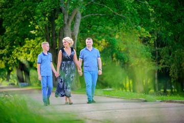 Fototapeta premium Family walking in the park, holding hands and talking