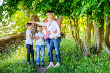 Fototapeta premium big happy family walking in the beautiful park at sunset, cuddling and having fun