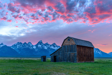 Sunset at Grand Teton - A sunset view of an abandoned old barn in Mormon Row historic district, at southeast part of Grand Teton National Park, with Teton Range rising high in the background, Wyoming.