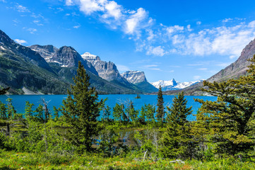 Spring at Saint Mary Lake - A panoramic view of high clouds passing over blue Saint Mary Lake and...