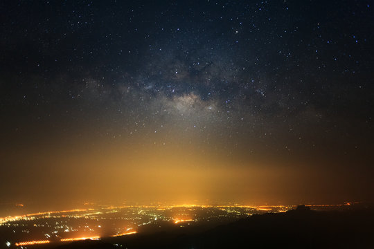 milky way galaxy with stars and space dust in the universe and city light at Phutabberk Phetchabun in Thailand.