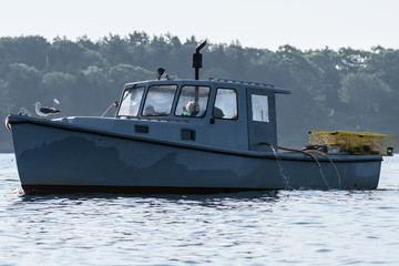 Lobster men hard at work on a beautiful morning in early autumn in South Bristol, Maine, United States