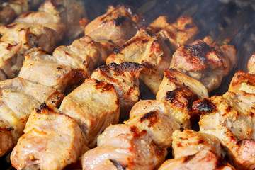 raw kebab grilling on metal skewer. Raw meat roasting at barbecue.