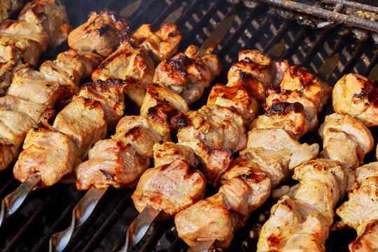 Marinated shashlik preparing on a barbecue grill over charcoal. Shashlik or Shish kebab