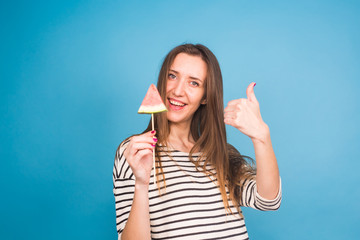 Summer, vacation, diet and vegans concept - Beautiful smiling young woman holding watermelon slice on stick