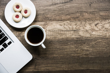 Top view home office table with laptop, coffee and cookie on wooden table. Modern office top view at home. New life style. Concept : business and office.