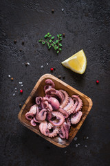 Seafood Baby octopus salad in a wooden bowl. Top view