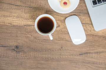 Top view home office table with laptop, coffee and cookie on wooden table. Modern office top view at home. New life style. Concept : business and office.