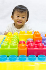 Fototapeta na wymiar Asian adorable baby one year is enjoying jigsaw toy for kid.