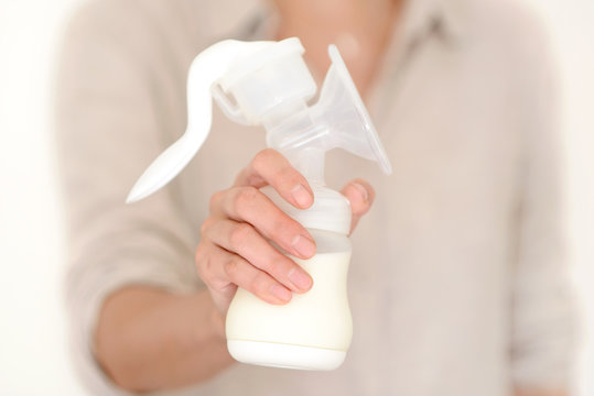 Mother holds breast pump in her hand