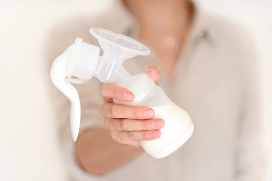 Mother holds breast pump in her hand