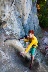 girl climber climbs the rock.