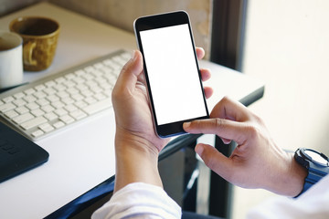 Business man using smartphone in office. Blank screen mobile phone for graphic display montage.
