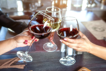 happy friends in a bar drinking red wine.