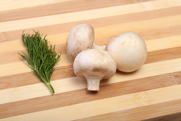 Fresh white mushrooms champignon on wooden background.