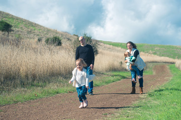Fototapeta premium Happy family of four hiking in the park with beautiful view