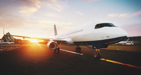 Fototapeta na wymiar White commercial airplane standing on the airport runway at sunset. Front view of passenger airplane is taking off. Airplane concept 3D illustration.