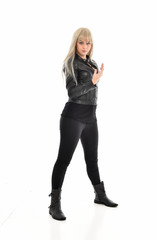 Fototapeta premium full length portrait of blonde girl wearing black leather outfit, standing pose on white background.