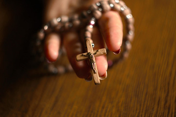 Fototapeta premium Woman Praying With Rosary Beads In Hand