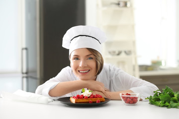 Female chef with tasty dessert in kitchen