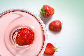 Glass of delicious strawberry wine on white background
