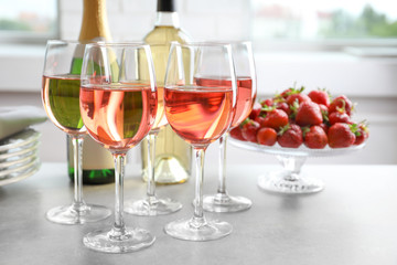 Glasses of strawberry wine on table