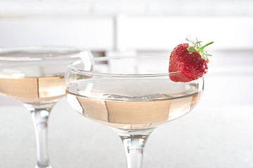 Glasses of delicious wine with strawberry on table